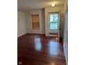 Bright living room featuring hardwood floors, a window with blinds, and an open doorway at 1254 Kenwood Dr, Greenwood, IN 46143
