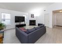 Spacious living room with a sleek gray sofa and fireplace offers a stylish and comfortable living space at 12722 Brady Ln, Noblesville, IN 46060