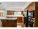 Bright kitchen featuring wood cabinets, black appliances, an island cooktop, and ample counter space at 13778 Driftwood Dr, Carmel, IN 46033