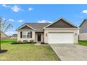Well-maintained brick home featuring a black front door and two-car garage at 1407 Allen Ct, Shelbyville, IN 46176