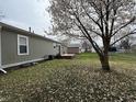 Large backyard with deck and several storage sheds and mature trees provides great outdoor space at 1424 Ashley Dr, Lebanon, IN 46052