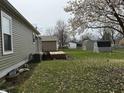 Large backyard with deck and several storage sheds and mature trees provides great outdoor space at 1424 Ashley Dr, Lebanon, IN 46052