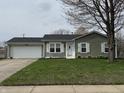 Charming single story home with green lawn and a two-car garage, enhanced by a mature shade tree at 1424 Ashley Dr, Lebanon, IN 46052