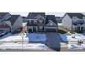 Aerial view of a two-story home with brick and siding, a two-car garage, and a snowy front yard at 15365 Todd S Ln, Fishers, IN 46037