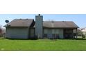 The backyard features a large grassy area with a covered porch perfect for outdoor living at 1631 Wilford Ln, Indianapolis, IN 46229