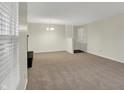 Bright living room with neutral carpet, paint, and light fixture at 1632 Queensbridge Sq # 7, Indianapolis, IN 46219