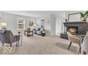 Bright living room featuring a fireplace, carpeted floors, and a comfortable seating area with natural light at 1632 Queensbridge Sq # 7, Indianapolis, IN 46219