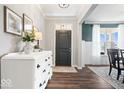 Bright entryway with wood floors, white dresser, and neutral walls leading into a dining area at 16688 Bowesmont Dr, Fortville, IN 46040