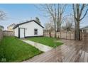 Backyard featuring a wooden deck, garage access, and a well-maintained lawn at 221 Eastern Ave, Indianapolis, IN 46201