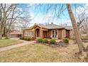Classic brick home with a red front door, front porch and mature trees providing shade at 251 E South St, Franklin, IN 46131
