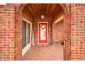Inviting front porch with brick archway, tiled flooring and a bright red front door at 251 E South St, Franklin, IN 46131