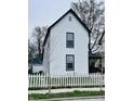 Exterior view of a two-story home with white siding and black trim, enhanced by a white picket fence at 310 N Monroe St, Muncie, IN 47305