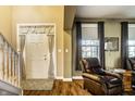 Bright foyer with hardwood floors, a staircase, and a view into a cozy living area at 3393 Paisley Pointe, Whitestown, IN 46075