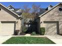 Charming townhouse exterior showcasing attached garages, well-maintained lawns and a classic brick facade at 3643 Reflections Ln # 5, Indianapolis, IN 46214