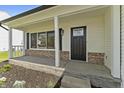 A close-up view of the front porch with a black front door and brick accents at 4057 Knollwood Ave, Franklin, IN 46131