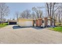 View of the home with brick facade, an attached garage, and gravel driveway at 4389 S Brooklawn Dr, New Palestine, IN 46163