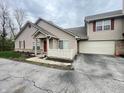 Inviting townhouse with garage, vinyl siding, brick foundation, and well-manicured landscaping at 4767 Kelvington Dr, Indianapolis, IN 46254