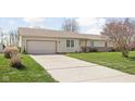 Well-maintained ranch home featuring a spacious driveway and a beautiful, green front yard at 5357 Collett E Dr, Camby, IN 46113