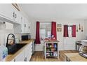 Bright kitchen with white cabinets, wooden countertops, and hardwood floors at 5427 E 19Th St, Indianapolis, IN 46218