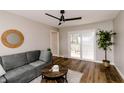 Living room featuring a gray sofa, hardwood floors, ceiling fan and sliding door to the deck at 5820 Bonnie Brae St, Indianapolis, IN 46228