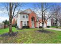 A two-story home featuring a brick facade, well-kept lawn, and mature trees at 6037 Porter Ln, Noblesville, IN 46062