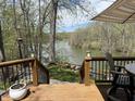 Outdoor deck with furniture overlooking lake, surrounded by trees and a manicured backyard at 7809 S Solitude Ln, Trafalgar, IN 46181