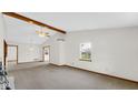 Open living room features large window and vaulted ceiling with exposed beams at 8242 Frankdale Ct, Indianapolis, IN 46259