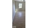 Bedroom featuring hardwood floors, a window offering natural light, and neutral-toned walls for a serene feel at 8277 Sobax Dr, Indianapolis, IN 46268