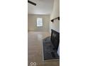 Bright living room with a stone fireplace, hardwood floors, and a large window illuminating the space at 8277 Sobax Dr, Indianapolis, IN 46268