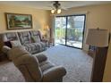 Living room features carpeting, sliding glass doors to the outside and comfortable seating at 8820 Yardley Ct # 103, Indianapolis, IN 46268