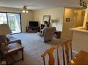 Bright living room features access to balcony, neutral carpeting and comfortable seating at 8820 Yardley Ct # 103, Indianapolis, IN 46268