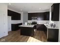 Modern kitchen featuring dark wood cabinets, white countertops, stainless steel appliances, and an island at 10027 Redwood Peak Ln, Indianapolis, IN 46259