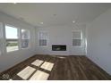 Bright living room with a modern fireplace, large windows offering ample natural light, and hardwood floors at 10027 Redwood Peak Ln, Indianapolis, IN 46259