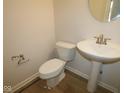 Practical half-bath with white pedestal sink and toilet; functional and efficient in design at 10543 Banyan Wood Ct, Indianapolis, IN 46239