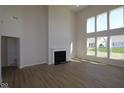 Bright living room featuring a fireplace, large windows, and hardwood floors at 10543 Banyan Wood Ct, Indianapolis, IN 46239
