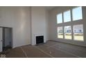 Bright living room with soaring ceilings, a cozy fireplace, and large windows offering abundant natural light at 10543 Banyan Wood Ct, Indianapolis, IN 46239