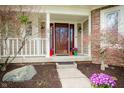 Inviting front porch with colorful flowers and stylish decor creating a warm entrance at 12507 Doe Ln, Indianapolis, IN 46236