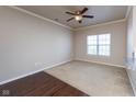 Well-lit bedroom with neutral carpet, a ceiling fan, and a window for natural light at 12926 University Cres # 2C, Carmel, IN 46032