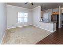 Spacious living room with carpet and wood-look flooring, ceiling fan, and a breakfast bar at 12926 University Cres # 2C, Carmel, IN 46032
