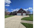 Beautiful brick home boasts a long driveway, two-car garage, and well-maintained lawn at 1513 Tottenham Dr, Danville, IN 46122