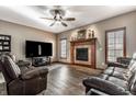 Comfortable living room with a fireplace, plush seating, and modern ceiling fan at 1513 Tottenham Dr, Danville, IN 46122