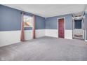 Spacious bedroom with neutral carpet, blue paneled walls, and ample natural light from the window at 1816 N Moreland Ave, Indianapolis, IN 46222