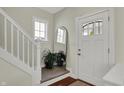 Bright foyer with white door, staircase and hardwood floors creates an inviting entrance at 2018 Cornell Ave, Indianapolis, IN 46202