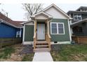 A delightful craftsman home showcasing green siding, white trim, a covered front porch, and fresh landscaping at 249 E Minnesota St, Indianapolis, IN 46225