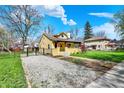 Exterior view of charming home, featuring a gravel driveway and well-maintained lawn at 3484 Birchwood Ave, Indianapolis, IN 46205