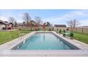 Sparkling in-ground pool with surrounding patio, complemented by outdoor furniture and a serene backyard setting at 4223 W State Road 234, McCordsville, IN 46055