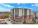 Condo building with brick and light colored siding, and balconies, surrounded by green trees and blue sky at 435 Virginia Ave # 402, Indianapolis, IN 46203