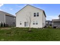 Rear view of the house displaying a grassy lawn and neutral siding at 4831 E Oak Hill E Dr, Lebanon, IN 46052