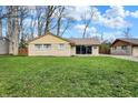 Well-maintained single-story home featuring a lush green lawn, mature trees, and charming curb appeal at 500 N Shellbark Rd, Muncie, IN 47304