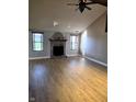 Spacious living room featuring a brick fireplace, large windows, and wood-look flooring at 52 Spring Lake Ct, Trafalgar, IN 46181